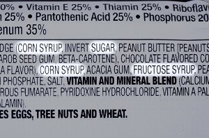 Closeup of ingredients list of granola health bar with forms of sugar highlighted