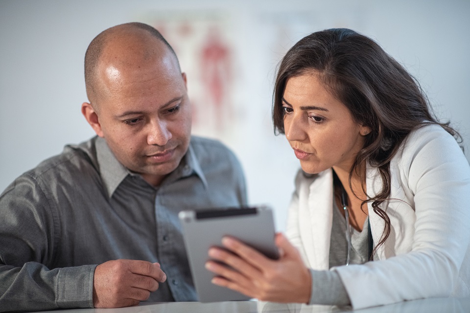 Female Dietitian Shares Information with Patient Using Digital Tablet